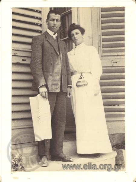 Portrait of a couple in front of a balcony door.
