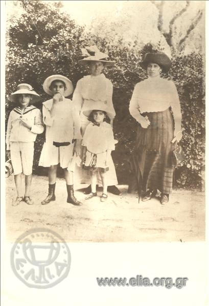 Portrait of two women and three children in a park.