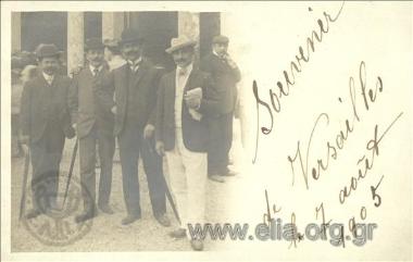 Portrait of four men with umbrellas.