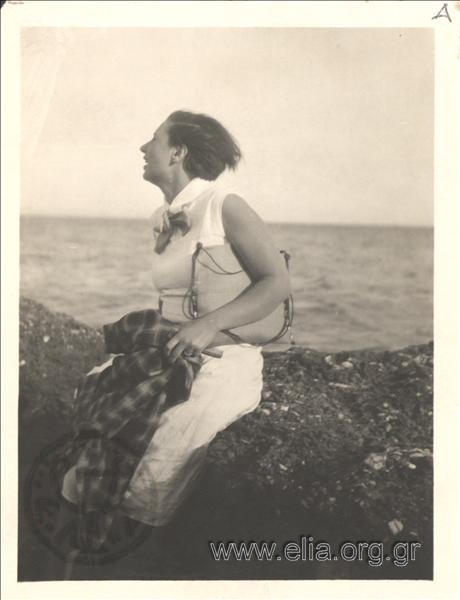 Γυναίκα σε βράχια δίπλα στη θάλασσα.