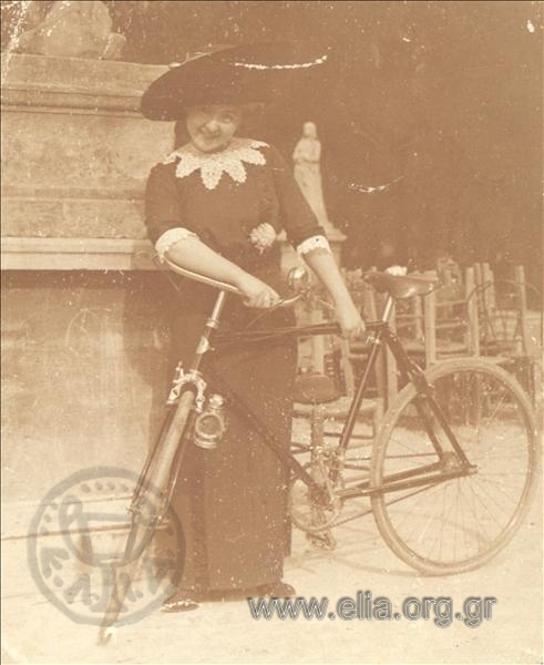 Portrait of a woman on a bicycle at a square.