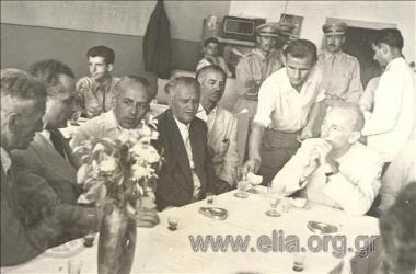 Panagiotis Kanellopoulos, Defence Minister  in Papagos government, talking with local authorities at a café.