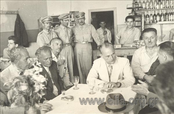 Panagiotis Kanellopoulos, Defence Minister  in Papagos government, talking with local authorities at a café.