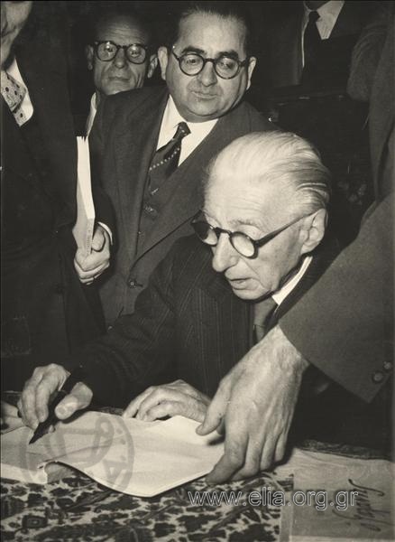 Ο Δημήτρης Γαλάνης υπογράφει αντίτυπα της βιογραφίας του σε εκδήλωση της Ελληνογαλλικής Ένωσης στην αίθουσα του Παρνασσού.