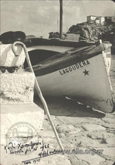 Composition with boat, heavy stick and navy hat.