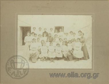 Ομαδικό πορτραίτο μαθητριών και διδασκαλισσών του Πρότυπου Παρθεναγωγείου. Όρθια, πρώτη από δεξιά, η διευθύντρια Άννα Τριανταφυλλίδου.
