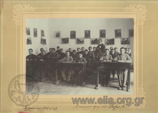 Group portrait of students of the 1st class of the Superior School in a classroom with a teacher.