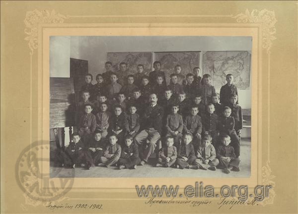 Group portrait of pupils of a department of the First Preliminary School in a classroom with a teacher.