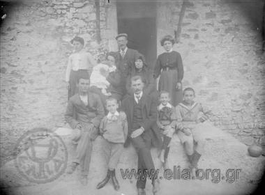Portrait of the family of Kanellos Kanellopoulos. Small Panagiotis Kanellopoulos standing next to his father, Kanellos.