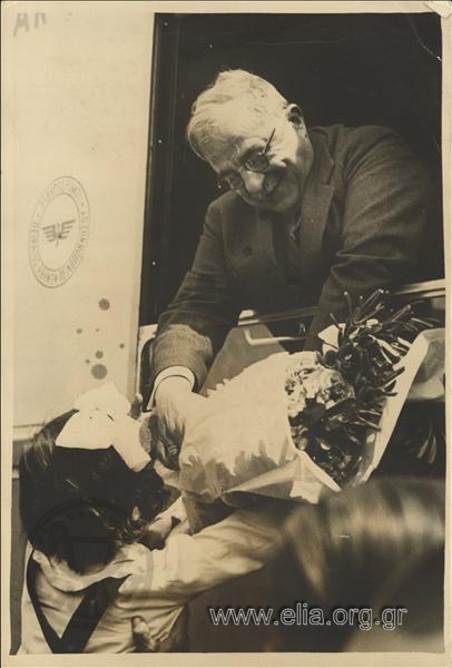 Ioannis Metaxas is offered a bunch of flowers through the window of a railway carriage, perhaps during his tour of the Peloponnese