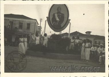 Μαθήτριες του Γυμνασίου Αγρινίου γύρω από πορτραίτο του Γεωργίου Β' στην κεντρική πλατεία Μπέλλου.