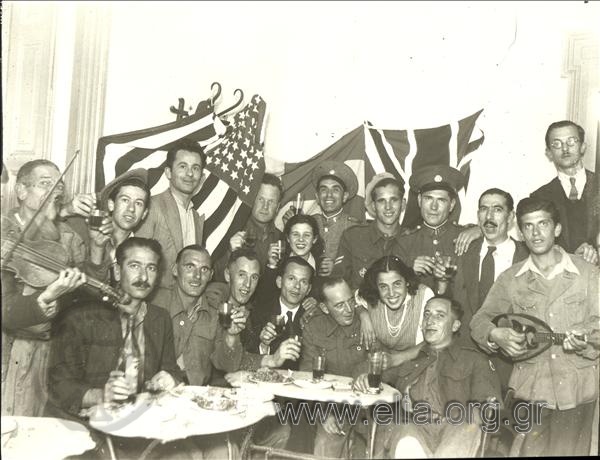 Έλληνες και Άγγλοι στρατιώτες και πολίτες γιορτάζουν την απελευθέρωση σε ταβέρνα.