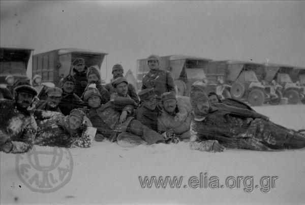 Στρατιωτικοί ποζάρουν στο χιόνι, πίσω τους όρχος μεταφορών.