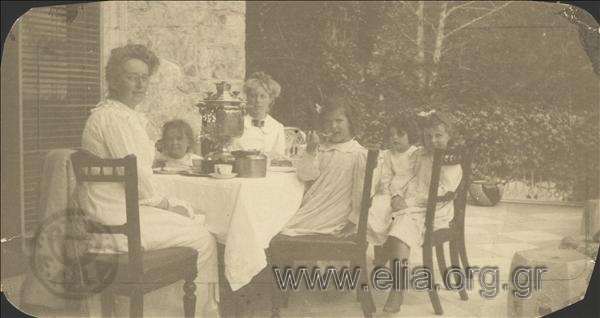 Ο Νικόλας Κάλας (1907-1988), παιδί, με τις πριγκίπισσες Μαρία, Ελισάβετ και Όλγα σε τραπέζι βεράντας.