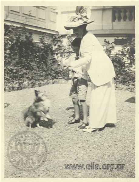 Nikolas Kalas (1907-1988) as a child with a woman and a dog in a garden at Champ Palace.