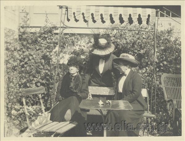 Από τη διαμονή της οικογένειας Καλαμάρη στο Palace. Τρεις κυρίες με ένδυμα περιπάτου κάθονται στον κήπο του ξενοδοχείου.
