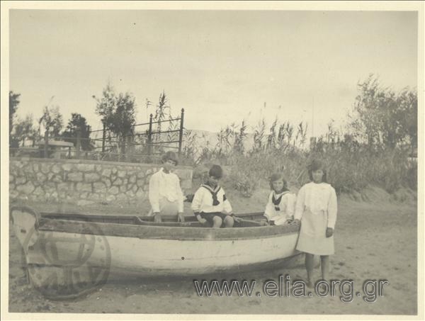 Ο Νίκης Καλαμάρης με άλλα παιδιά σε βάρκα στην παραλία.