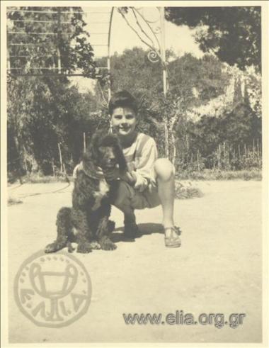 Nikolas Kalas (1907-1988) as a child with a dog in a garden in Kifisia.