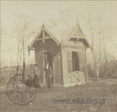 Δύο νεαροί μπροστά σε ξύλινο περίπτερο.