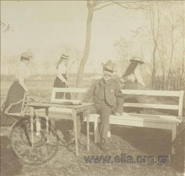 Man and three young women with tennis rackets in a park