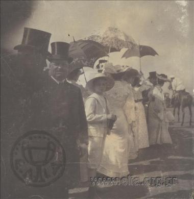 Επίσημοι παρακολουθούν στρατιωτική επιθεώρηση.