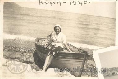 Γυναίκα σε βάρκα δίπλα στη θάλασσα.