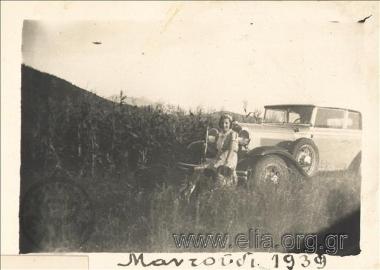 Woman with a shotgun by a car