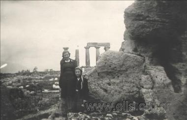 Δύο γυναίκες σε αρχαιότητες, στο βάθος ο Ναός του Απόλλωνα.