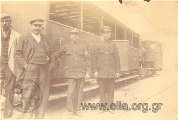 Railroad men in front of carriages.
