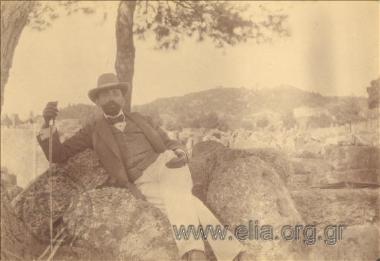 Άνδρας ακουμπά σε βράχο.