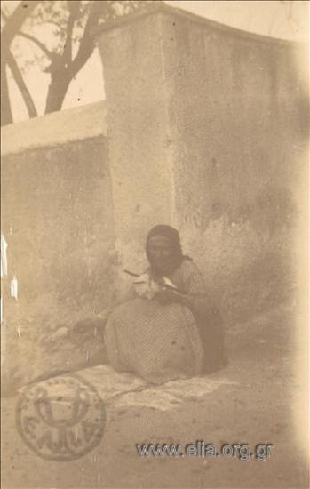Ηλικιωμένη γυναίκα γνέθει μαλλί.
