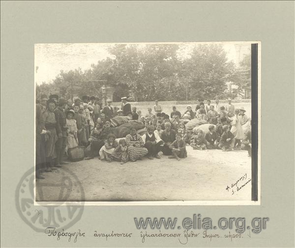 Refugees with children outside the Municipal Public Garden waiting to be provided with lodging