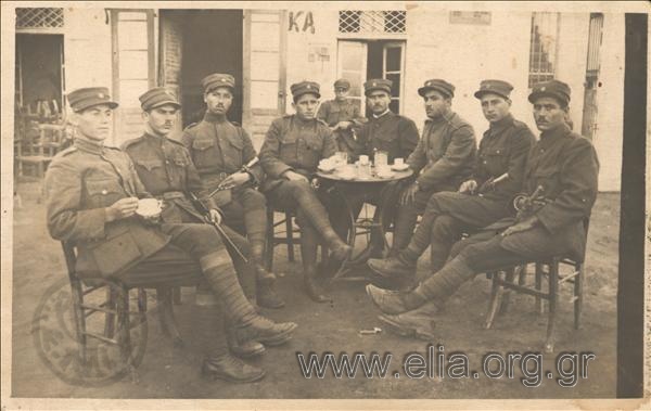 Group portrait of eight soldiers in a coffeehouse.
