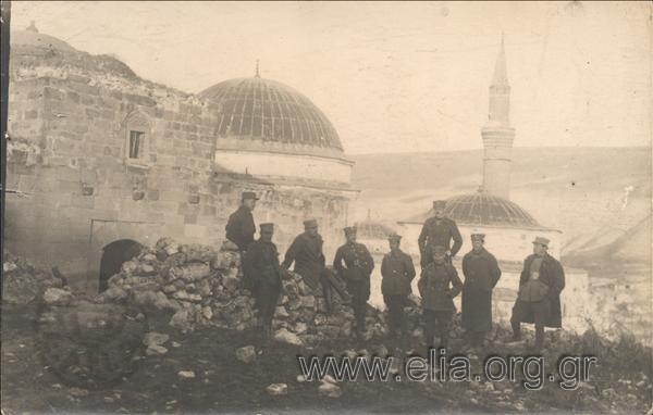 Portrait of nine rank-holder servicemen in front a church with minaret.