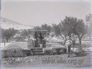 Γυναίκες βγάζουν νερό από πηγάδι για να μεταφερθεί με γαϊδούρι.