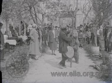 Αρκουδιάρης, η Ίρις και κόσμος που παρακολουθεί.