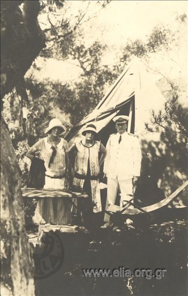 Gerasimos V. Vasiliadis and two women outside a tent
