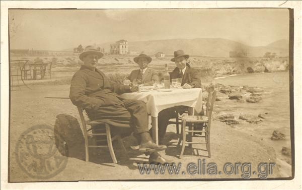 Gerasimos V. Vasiliadis and two other men at a seaside restaurant