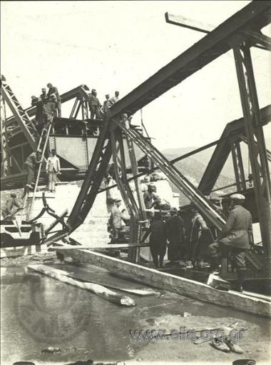 Greek  soldiers worKing at a destroyed steel bridge