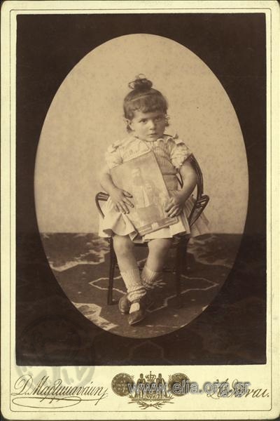 Η Πολύμνια Γ. Αθηνογένη(;) κρατώντας φωτογραφία του Στέφανου Σκουλούδη με στολή διπλωμάτη.
