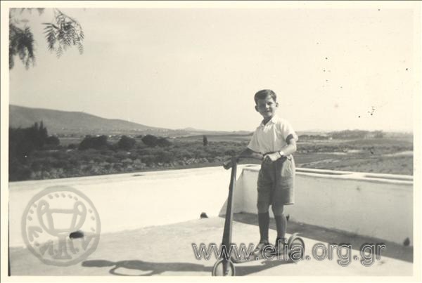 Little Marinos I. Geroulanos on a veranda with a skate.