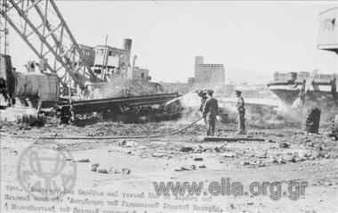 Πυροσβέστες προσπαθούν να σβήσουν φωτιά στο λιμάνι μετά το βομβαρδισμό από τις αποχωρούσες γερμανικές δυνάμεις κατοχής.
