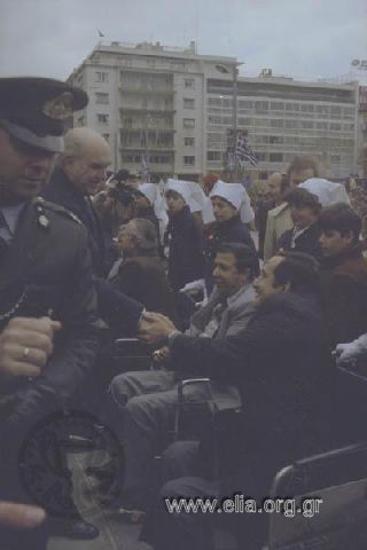 Εορτασμός της 25ης Μαρτίου: ο πρωθυπουργός Ανδρέας Παπανδρέου χαιρετά ανάπηρους πολέμου.