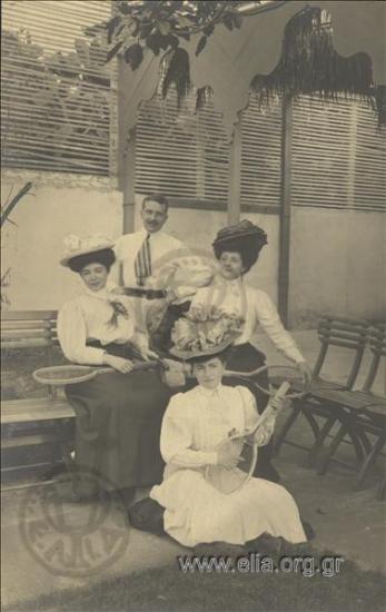 Three women with tennis rackets and a man.