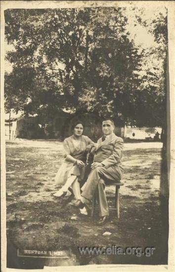 A couple sitting at the shade of the sycamores.