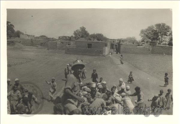 Στρατιωτικός με Βρετανική στολή εκστρατείας (θερινή). Σε δεύτερο πλάνο, οικισμός Αράβων, παιδιά συγκεντρωμένα.