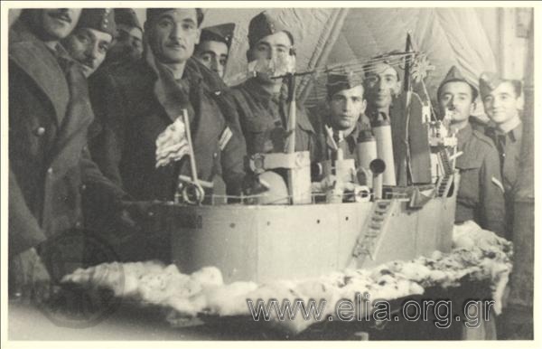 Έλληνες στρατιώτες και υπαξιωματικοί γύρω από μοντέλο πλοίου.