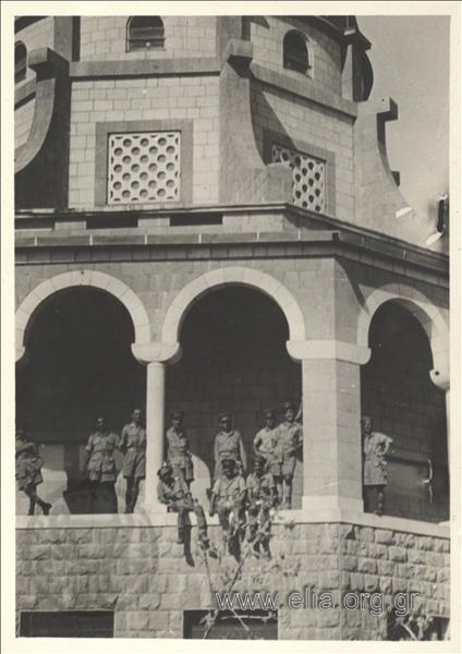 Greek  soldiers in summer campaign uniform at a monument  (temple?)