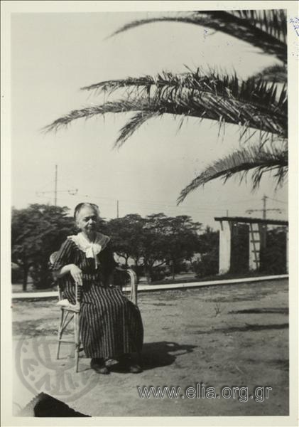 Μία από τις θείες του Νικολάου Τομπάζη, καθιστή, σε κήπο.