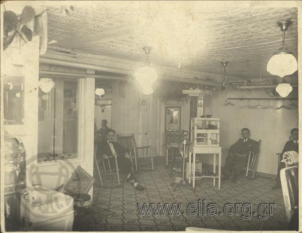 Interior view of a barbershop with customers.